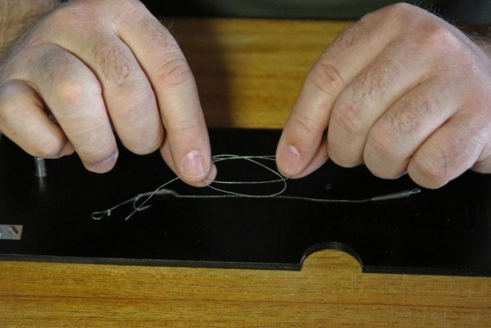 22. Steek het uiteinde door de dubbele lus en leg deze nu rond je haakbocht.